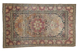 Antique Isfahan rug with elaborate cochineal red floral medallion on a pale sand bronze field.
