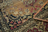 Corner detail of an antique Persian Isfahan rug with navy floral border and pale sand rococo design.