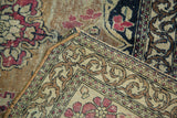 Antique Isfahan rug corner showcasing scrolling rococo border, cochineal floral motif, and exposed foundation.