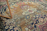 Patinaed texture of antique Isfahan rug with cochineal red, navy, and pale sand bronze floral motifs.