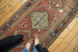 Antique Karaja runner's geometric green medallion, brick red field, and contrasting border displaying historic wear.