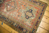 Karaja runner showcasing geometric pinwheel motifs, brick red, navy, and pale green tones with tattered edge.
