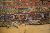 Antique Karaja runner's geometric border in navy, brick red, and beige with natural tatter.