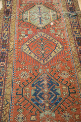 Karaja runner detail: geometric medallion and hook motifs in brick red and navy time-softened tones.