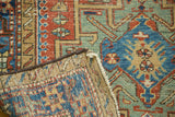 Folded antique Karaja runner corner, revealing geometric motifs, vibrant colors, and hand-knotted foundation.