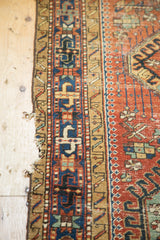 Antique Karaja runner side with geometric navy, gold border, brick red field, and aged, storied edge.