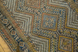 Interlocking geometric design on a vintage Afshar runner with navy, gold, and warm earth tones.