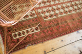 Vintage Turkmen rug corner with blush and brown borders, tattered fringe and missing edging.