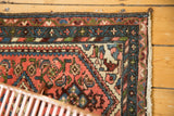 Vintage Borchalou rug corner, blush Herati field, sky blue barber pole border, and fringe.