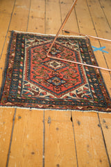 Vintage Borchalou rug corner with dark blush field, meandering leaf, and barber pole borders.
