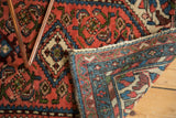 Vintage Borchalou rug corner showing hand-knotted reverse and blush, blue patterned borders.
