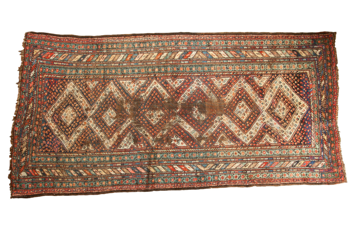 Vintage Caucasian runner rug, six concentric diamond medallions, madder red and navy blue, localized wear, 4'5" x 9'1".