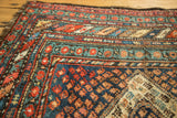 Geometric patterns of a vintage Caucasian runner corner, with navy, red, teal, and ivory colors.