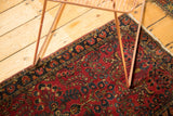 Vintage Sarouk runner corner, dark cherry red field, blossom and vine pattern, navy border.