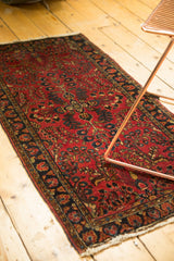 Vintage Sarouk runner with a dark cherry red field, navy floral vinery, and tattered fringe.
