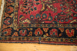 Vintage Sarouk runner: cherry red field with blossoms, navy border, and worn edge.