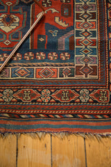 Antique Kamseh rug's lower corner, featuring intricate geometric borders and raw fringed edge.