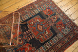 Upper corner of antique Kamseh rug, rich navy and madder red geometric motifs, tattered ends.