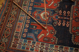 Antique Kamseh rug's hand-knotted geometric border with madder red and indigo blue patterns.