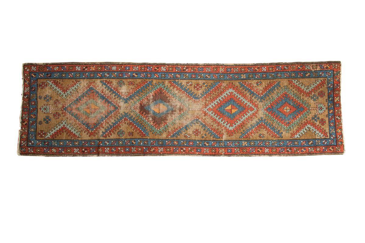 Vintage Bakshaish runner, geometric diamond medallions in warm camel, red, blue, and orange tones.