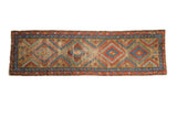 Vintage Bakshaish runner, geometric diamond medallions in warm camel, red, blue, and orange tones.