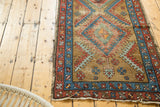 Worn fringe and geometric madder root red, sky blue border on vintage Bakshaish runner.