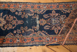 Central distress on the antique Lilihan runner, highlighting navy blue ground and blush floral motifs.
