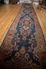 Antique Lilihan rug detail showcasing navy blue ground with blush and terra cotta curvilinear floral motifs.