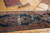 Tattered end of antique Lilihan runner, navy blue field and terra cotta floral border.