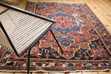 Close-up of Vintage Baktiari rug, distressed pile with red, navy, saffron geometric patterns.
