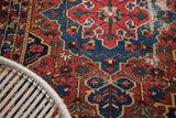 Distressed vintage Persian Baktiari rug showing bold red, navy, and saffron geometric pattern.