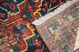 Distressed red, navy, yellow Baktiari rug pile, with cream fringe and hand-knotted back.