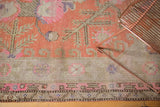 Antique Khotan carpet detail: terra cotta field with bold geometric motifs, beige and pink floral border.