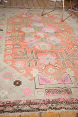 Upbeat Khotan rug featuring pale terra cotta, bubblegum pink, ivory, and lavender floral motifs.