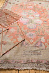 Secured fringe and distressed pink-terra cotta pattern along an antique Khotan rug's edge.