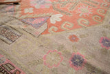 Antique Khotan carpet with even distress, pale pink, purple, and terra cotta motifs.