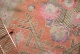Distressed texture of antique Khotan carpet with bright terra cotta and bubblegum pink.