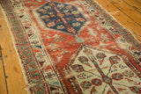 Antique North West Persian runner detail: worn madder root red field, geometric sea foam green border with tatter.