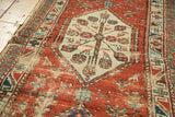 Antique North West Persian runner: ivory hexagonal medallion with floral motifs, textured pile wear.