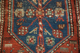 Antique North West Persian rug's navy blue, madder red medallion with bursting floral, bird motifs, varied pile.