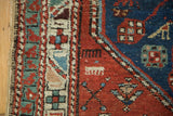 Textured antique North West Persian rug pile: madder root red, navy blue field, geometric border.