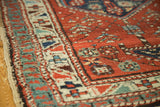 Antique North West Persian runner's madder red field, stylized plant motifs, and varied pile.