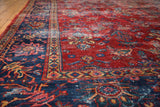 Distressed vintage Persian Mahal carpet featuring a faded navy border and red floral field.