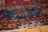 Visually textured distress on navy and red vintage Mahal rug, revealing foundation.