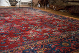 Distressed vintage Mahal carpet with worn cherry red field, floral patterns, and visible foundation.