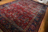 Distressed vintage Mahal carpet, cherry red field with pale blue, saffron florals and navy border.