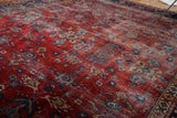 Textured distressed surface of the cherry red Mahal carpet, featuring splayed floral motifs.