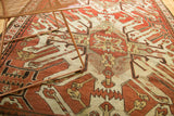 Vintage Kazak carpet with geometric eagle motifs in rust, ivory, and charcoal colors.