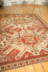 Vintage Kazak rug corner, rust and ivory geometric motifs, stylized animal figures, and fringe.