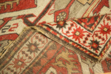 Folded vintage Kazak rug showing hand-knotted geometric pile and woven foundation.